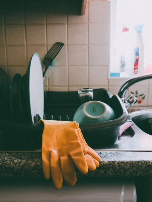 Un employé équipé d’un vêtement de protection désinfecte une cuisine, assurant un cadre propre et sécurisé.